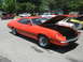 1972 Ford Ranchero - Orange 1972 Ford Ranchero GT parked at a car show, hood up, with other vehicles visible.
