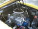 1972 Ford Ranchero - The engine bay of a yellow vehicle, a V8 engine with a chrome air cleaner and visible hoses and wiring.