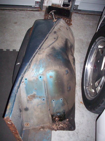 Blue fender part with rust and dents