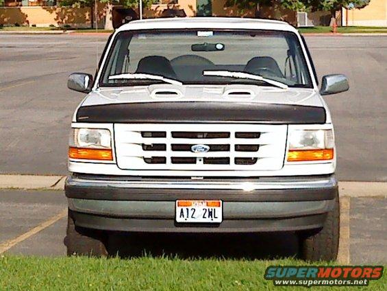 Front view of a white 1995 Ford Bronco parked on grass