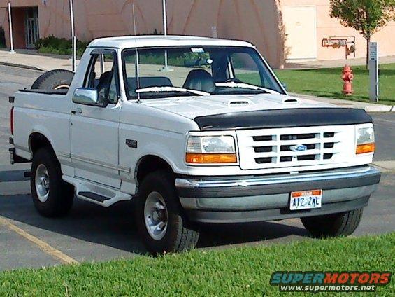White 1995 Ford Bronco parked on grass with a fire hydrant in the background