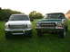 2000 Ford Excursion - Two Ford trucks, a white Excursion and a green older model, are parked side-by-side on a grassy field.