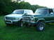 2000 Ford Excursion - A white 2000 Ford Excursion is parked on a grassy lawn next to a green Ford Bronco.