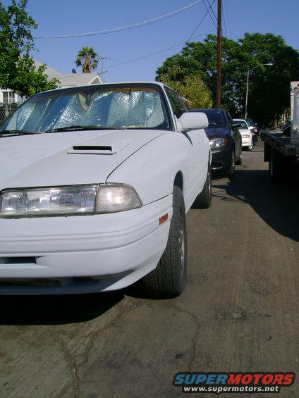White Mazda MX-6 with a hood scoop and sunshade, parked on a street