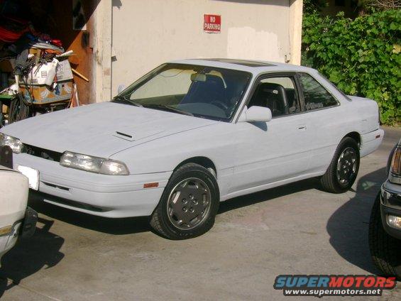 1989 Mazda MX-6 coupe, primer gray, with sunroof, parked next to another vehicle