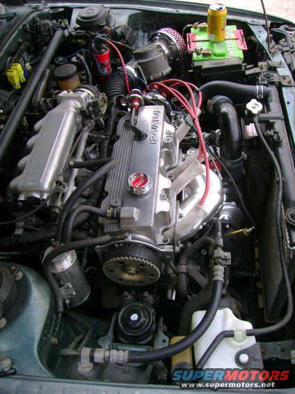 Engine bay with a 12-valve engine, aftermarket air intake, and a can of soda on the battery