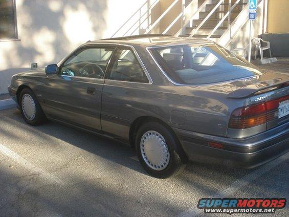 Gray Mazda MX-6 parked outside a building with stairs in the background