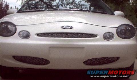Front view of a white 1997 Ford Taurus with a black grille and fog lights
