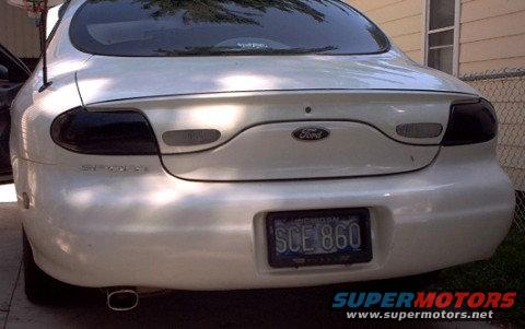 Rear view of a white 1997 Ford Taurus sedan with tinted taillights and a Michigan license plate