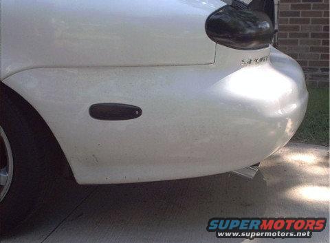 White 1997 Ford Taurus rear quarter panel with a black side marker and a small exhaust tip visible