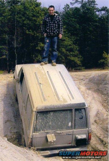 Tan 2005 Ford Excursion stuck in a ditch, rear view