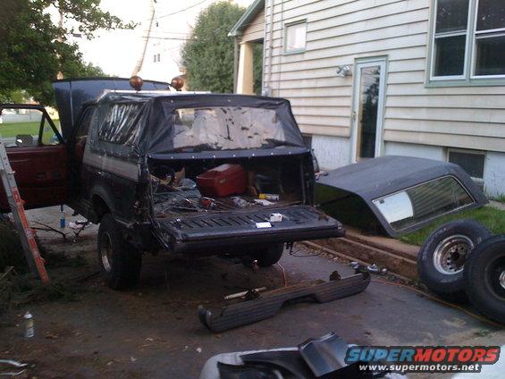 Black soft top Bronco with open tailgate and removed hardtop nearby