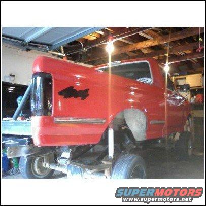 red pickup truck with black 4x4 decal on fender, in garage