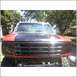 1994 Ford F-250 - This lifted Ford F-Series truck features a two-tone red and black paint scheme with a prominent black grille.