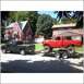 1994 Ford F-250 - A lifted red 1994 Ford F-250 is transported on a trailer, towed by a black pickup truck.