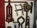 1909 Ford Model T - Vintage automotive tools, including a red screw clamp and a Chevrolet emblem, are organized on a wooden board.
