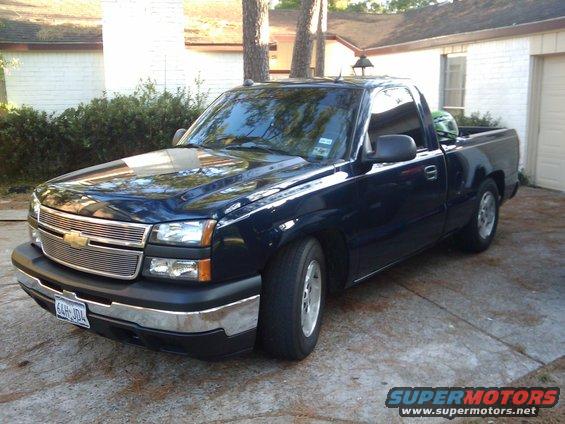 Dark blue pickup truck parked in a driveway, front quarter view. License plate reads 6AH-J04