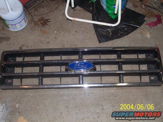 Chrome and black Ford grille with blue oval emblem
