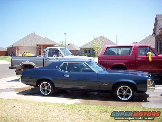 Dark blue coupe parked next to a pickup truck and a red SUV