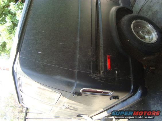 Black van side view, dusty, with a red reflector and chrome trim