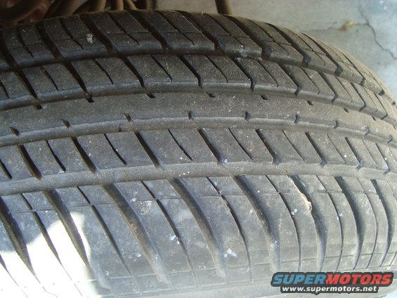 Close-up of a tire tread with SuperMotors.net logo
