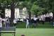 1996 Ford Bronco - A park scene with pedestrians, parked cars, and a police officer on a bicycle.