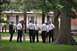 1996 Ford Bronco - Several men, some in uniform, stand in a grassy area near a large tree and a building.