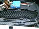 2001 Dodge 2500 - A shotgun is secured in a padded case within the bed of a pickup truck, alongside various tools and a blue gas can.