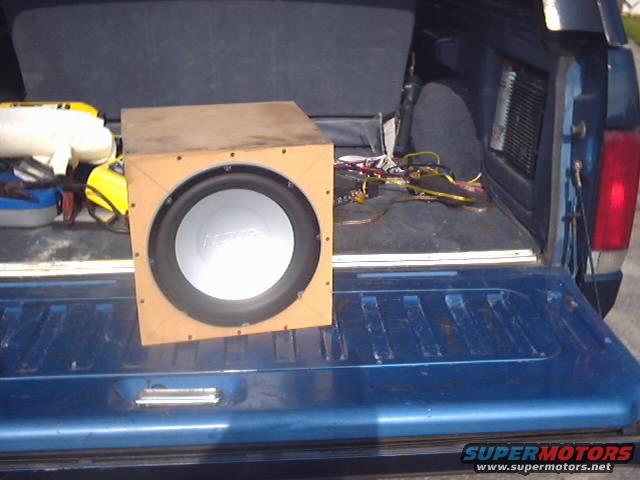 subwoofer box in open tailgate of blue pickup truck