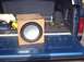 1990 Ford Bronco - A subwoofer box sits in the bed of a blue pickup truck, with wiring and other items visible.