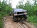 1994 Ford F-250 - A lifted 1979 Ford pickup truck navigates a challenging off-road trail with a woman standing nearby.