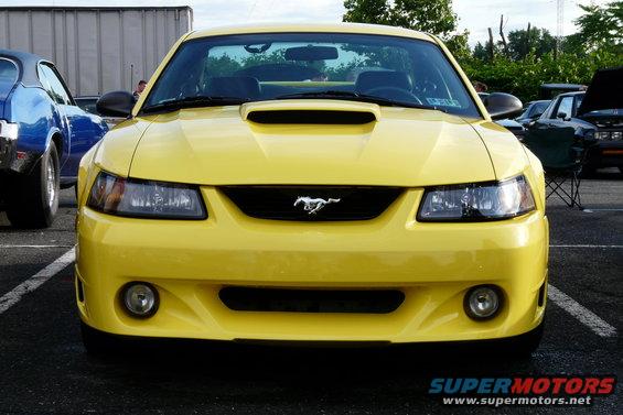 Yellow 2002 Ford Mustang front view with a blue car to the left