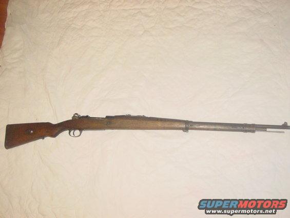 Bolt-action rifle with wooden stock and metal barrel, laid out horizontally
