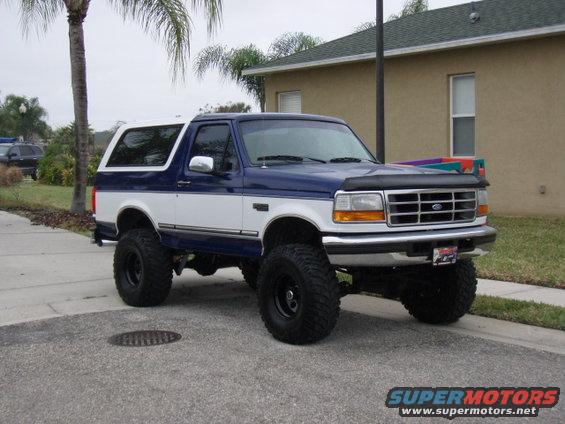Lifted 1996 Ford Bronco, blue and white, parked on a street