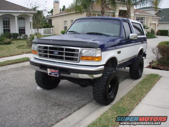Blue and white 1996 Ford Bronco with lifted suspension and large tires