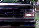 1995 Ford Bronco - Front view of a white Ford Bronco, showing the grille and headlight assembly. The vehicle appears to be from the early to mid-1990s.