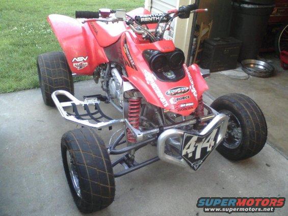 Red ATV with racing tires and number 414 on the front bumper