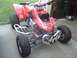 2004 Honda TRX 400 EX - A red ATV with racing tires and a prominent number 414 on its front bumper sits on a concrete surface.