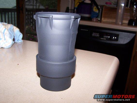 Black plastic part with a lid and a banded base