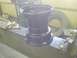 1985 Ford Ranger - A black steel wheel rim is shown resting on a metal workbench in a workshop setting.