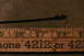 2002 Ford Mustang - A dipstick is shown next to a measuring tool, with some text and numbers visible on the tool.