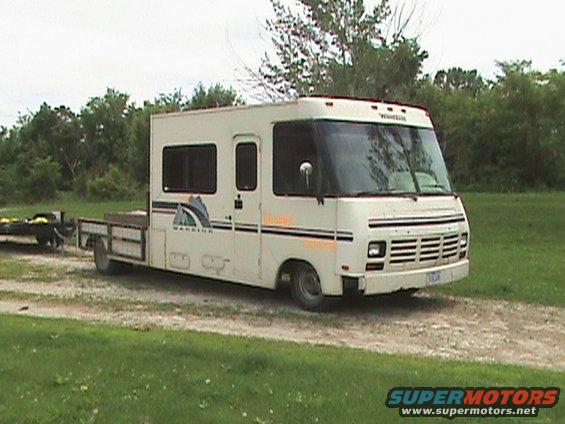 White motorhome with flatbed trailer, 3q-front view