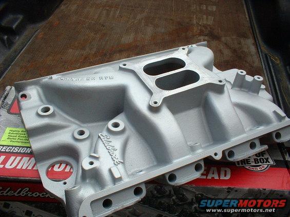 Silver Edelbrock intake manifold with dual carburetors