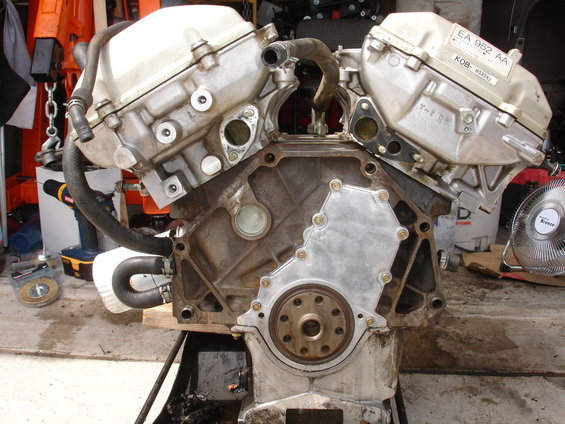 V6 engine block on a stand, with hoses attached. Label on top reads EA 952 AA KOB-653291