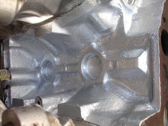 Inside of a silver-painted engine block with bearing journals visible
