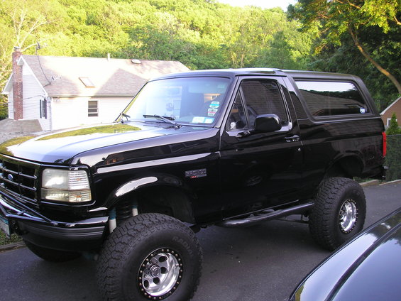 Black Ford Bronco with lifted suspension and off-road tires, viewed from the front three-quarter angle