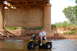 1985 Ford Ranger - A man sits on a yellow three-wheeled ATV in the water beneath a large concrete bridge.