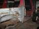 1978 Ford Bronco - This red truck body shows significant rust and damage, with parts of the interior visible.