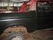 1978 Ford Bronco - A 1978 Ford Bronco is shown in a garage, undergoing restoration with a black lower body and red upper body.