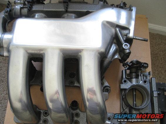 Polished aluminum intake manifold and throttle body assembly, likely for a car engine